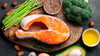 FITFARMin keto-valmennusten ruokavalioon sopivia ruoka-aineita. Lohi, parsa, pähkinöitä, avocado, öljyä, parsakaalta ja siemeniä.