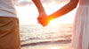 Pariskunta pitelee toisiaan kädestä kiinni rannalla. Jutta Larmin parisuhteen perustana on rakkaus. 