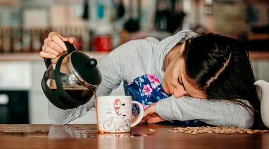 Kun jaksaminen on äärirajoilla, energiaa ei riitä mihinkään. Nainen kaatamassa väsyneenä kahvia kahvikuppiin.